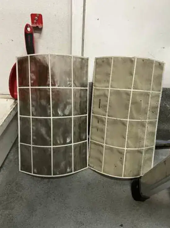 Two mini split filters side by side, one dark with dust