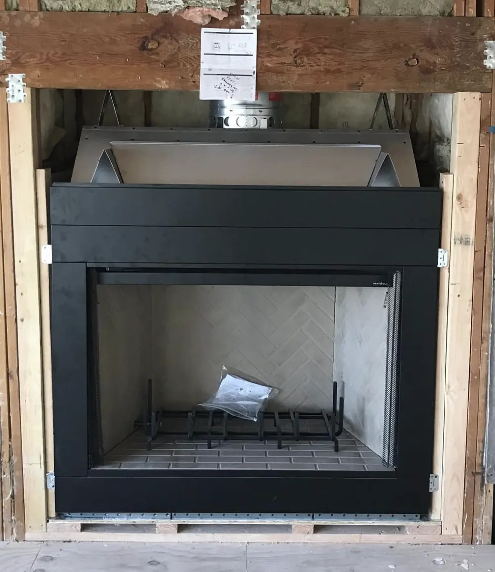 A wood burning firebox set square in a framed wall opening